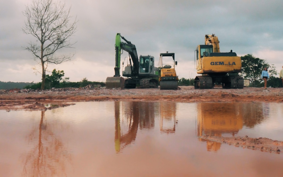 Construction excavators at a site with muddy water